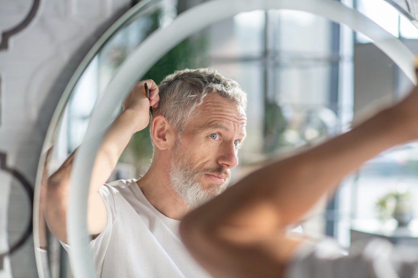 Creating a hairstyle. A man combing his hair in the morning