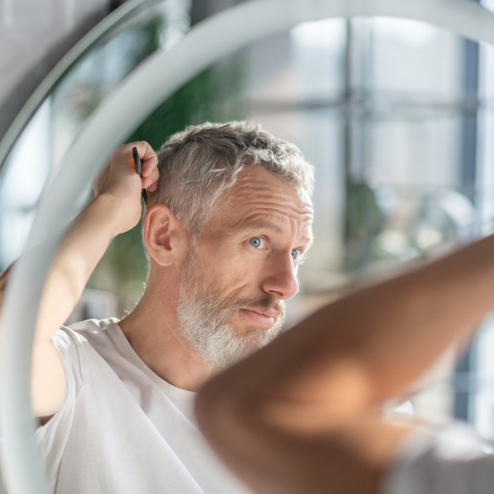 Creating a hairstyle. A man combing his hair in the morning